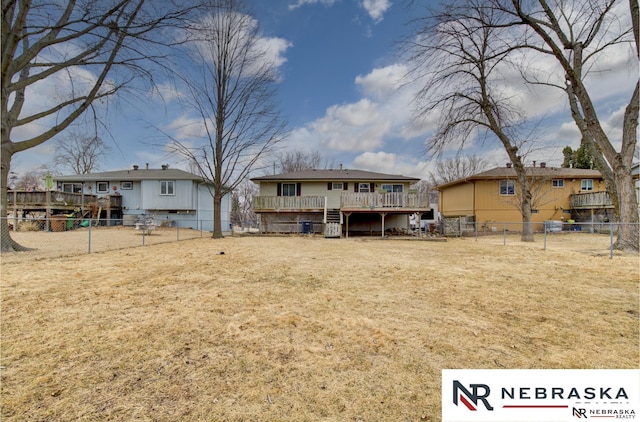 back of house featuring a fenced backyard, a deck, and a yard