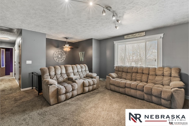 living area with a textured ceiling, track lighting, carpet flooring, and baseboards