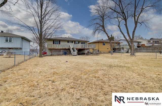 rear view of property with a deck, a fenced backyard, and stairs