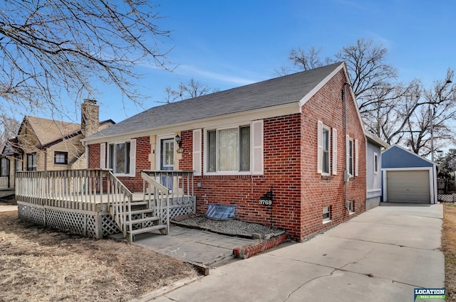 view of front of property with an outbuilding, brick siding, a detached garage, driveway, and a wooden deck