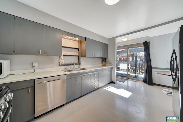 kitchen featuring appliances with stainless steel finishes, gray cabinets, light countertops, and a sink