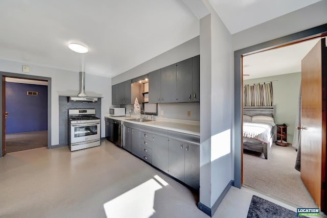 kitchen featuring dishwasher, white microwave, light countertops, stainless steel range with gas cooktop, and a sink