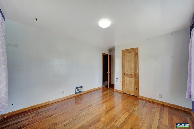 unfurnished room with light wood-style flooring and baseboards