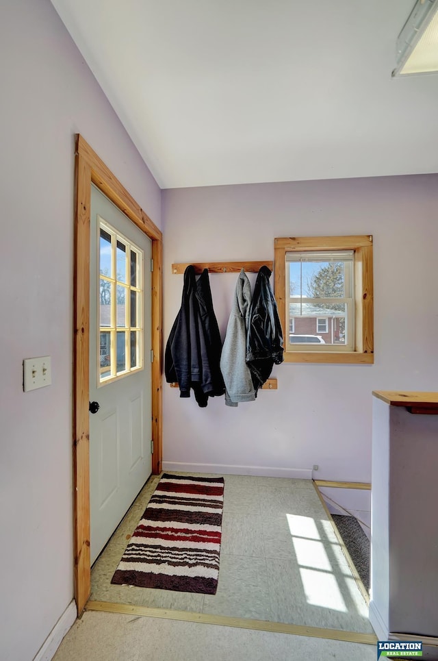 doorway to outside featuring baseboards