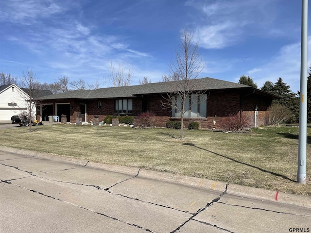 ranch-style house with a front lawn, brick siding, a shingled roof, and an attached garage