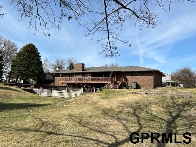 exterior space with a deck, a chimney, a front yard, and fence