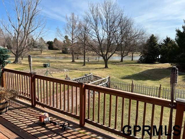 wooden terrace featuring fence and a lawn