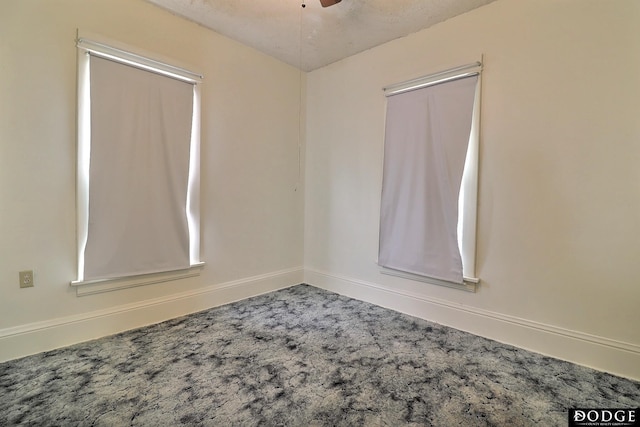 empty room featuring ceiling fan, carpet, and baseboards