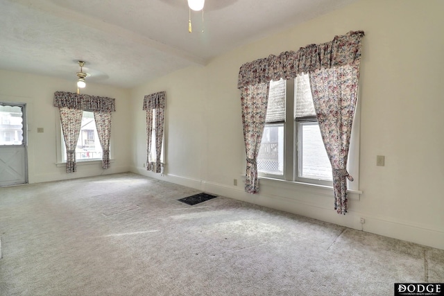 empty room featuring ceiling fan, carpet, visible vents, and baseboards