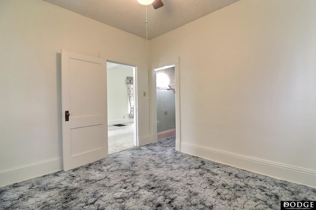 carpeted spare room featuring a ceiling fan and baseboards