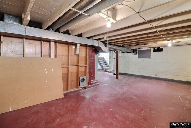 unfinished basement with stairway and concrete block wall