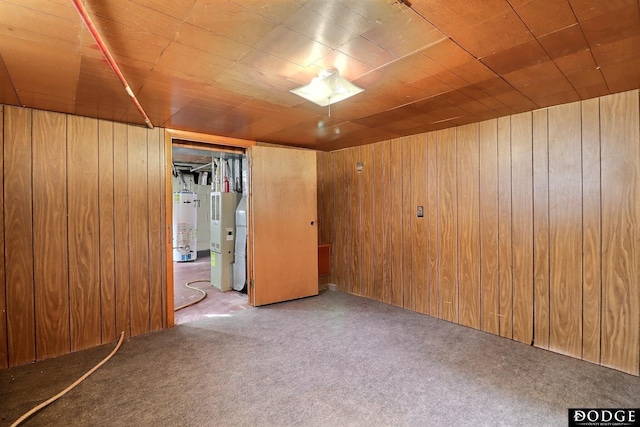 interior space featuring gas water heater, carpet flooring, and wooden walls