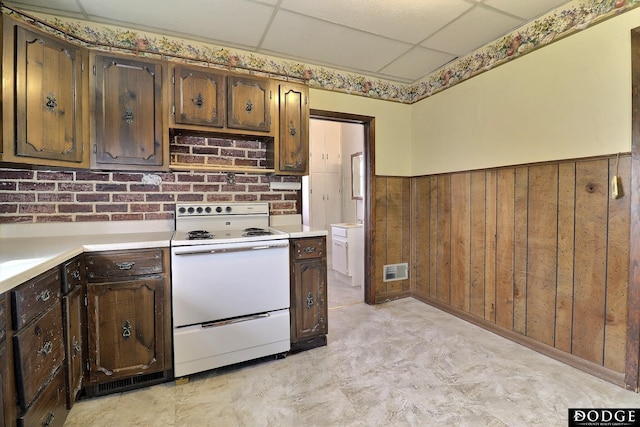 kitchen with visible vents, a wainscoted wall, light countertops, a paneled ceiling, and white range with electric cooktop