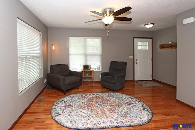 interior space with light wood-style flooring, visible vents, baseboards, and a ceiling fan