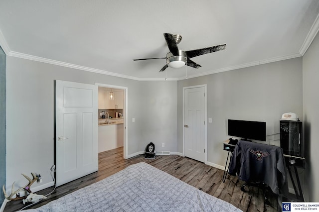 bedroom with ornamental molding, wood finished floors, and baseboards