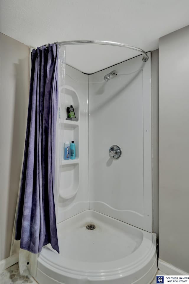 bathroom with curtained shower and baseboards