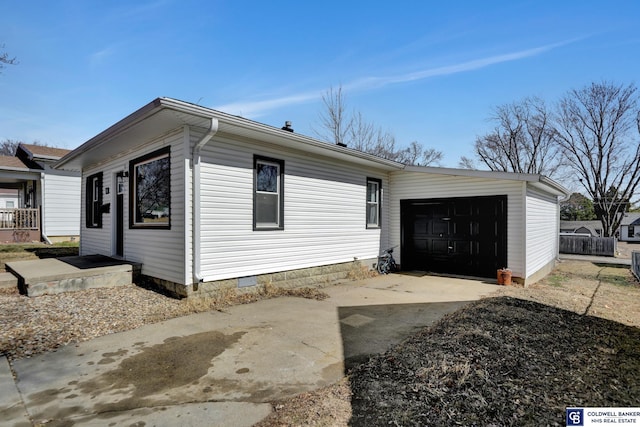 exterior space with a garage, concrete driveway, and crawl space