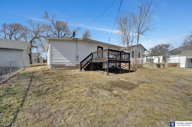 back of property featuring fence, a deck, and a yard