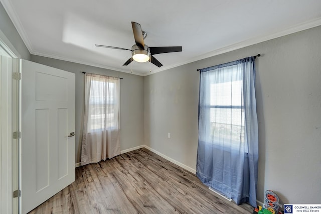 unfurnished bedroom featuring baseboards, wood finished floors, a ceiling fan, and crown molding