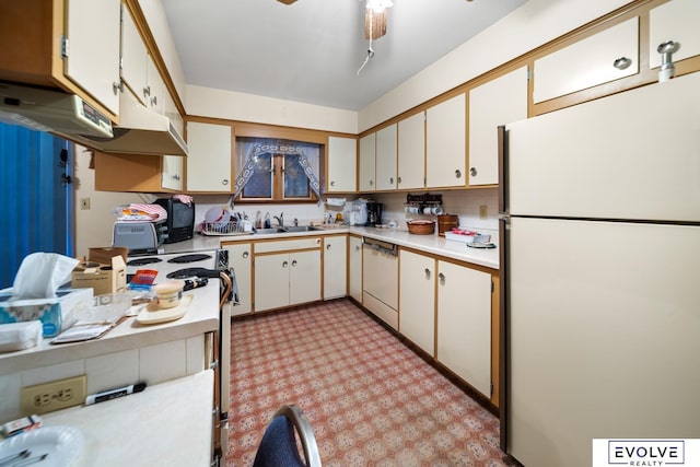 kitchen featuring a sink, under cabinet range hood, white appliances, light countertops, and light floors