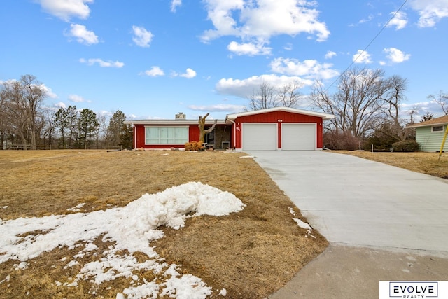 view of front of house featuring concrete driveway, an attached garage, and a front yard