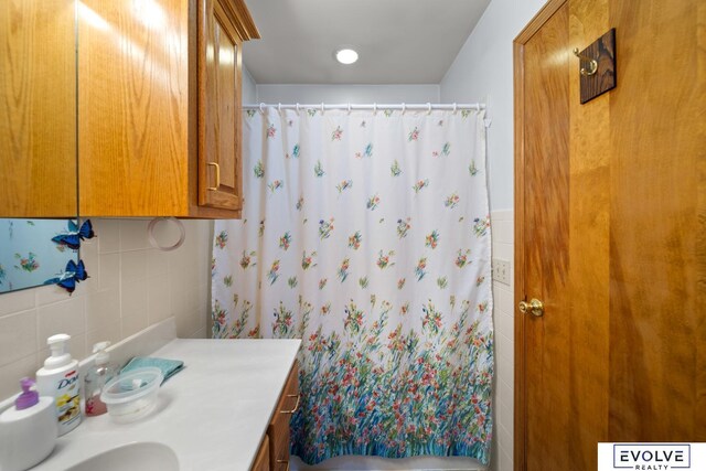 full bath with vanity, a shower with shower curtain, and backsplash