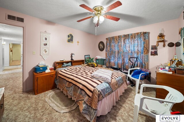 carpeted bedroom featuring visible vents, a textured ceiling, and ceiling fan