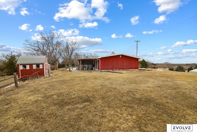 view of yard with an outbuilding, a storage unit, and fence