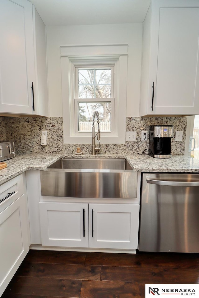 kitchen with a sink, tasteful backsplash, white cabinets, and dishwasher