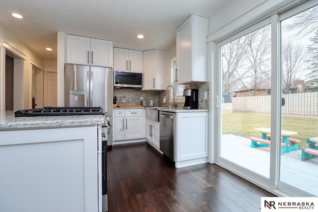 kitchen featuring dark wood-style floors, white cabinetry, stainless steel appliances, and backsplash