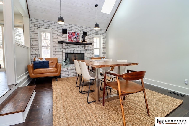 dining room featuring lofted ceiling, plenty of natural light, a fireplace, and visible vents