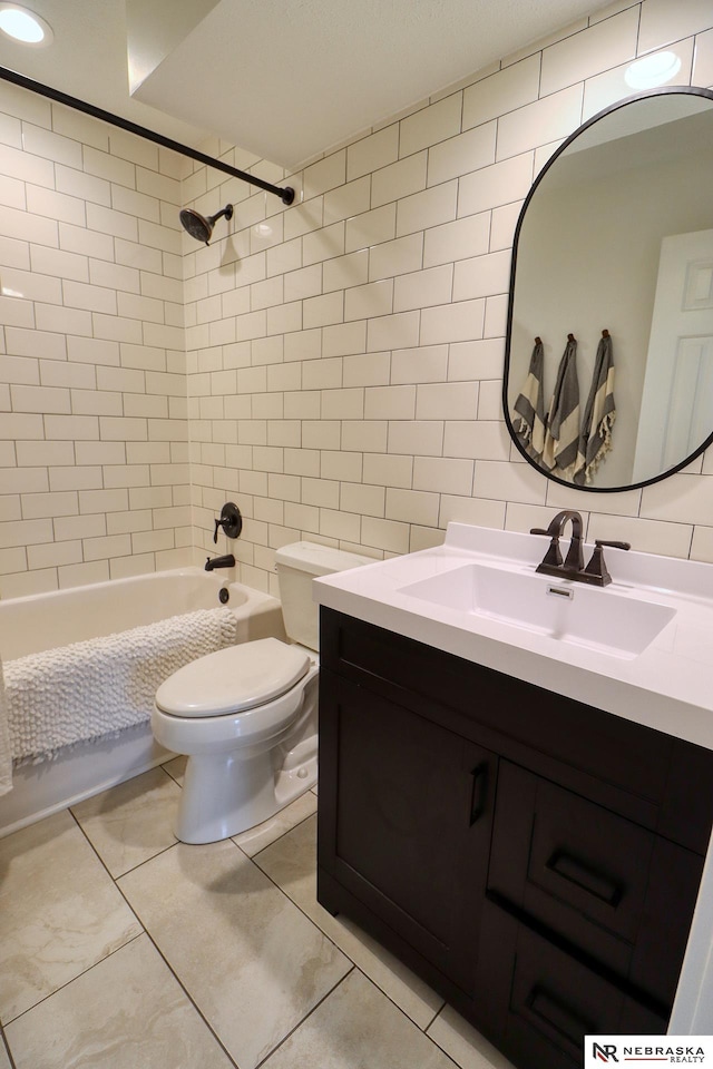 bathroom with tile walls, tasteful backsplash, toilet, vanity, and  shower combination