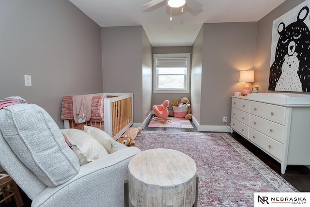 living area with ceiling fan and baseboards