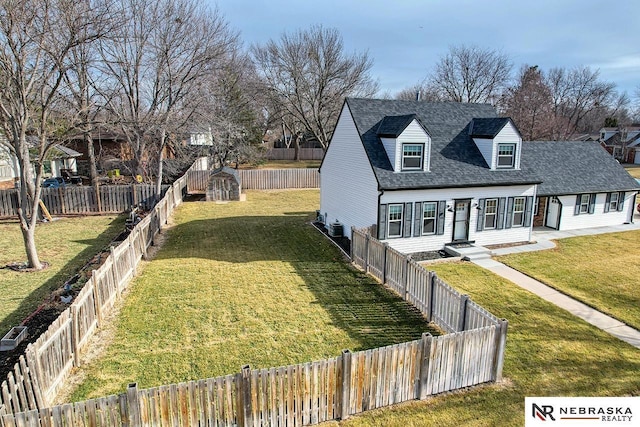 exterior space featuring a shingled roof, a front yard, and a fenced backyard