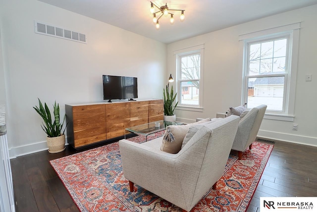 living room with baseboards, visible vents, and dark wood-type flooring