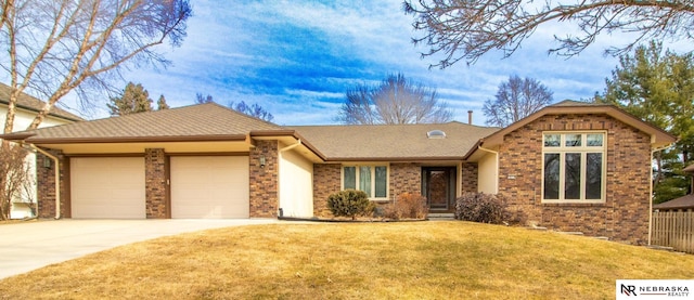 view of front of home with driveway, an attached garage, a shingled roof, and a front yard