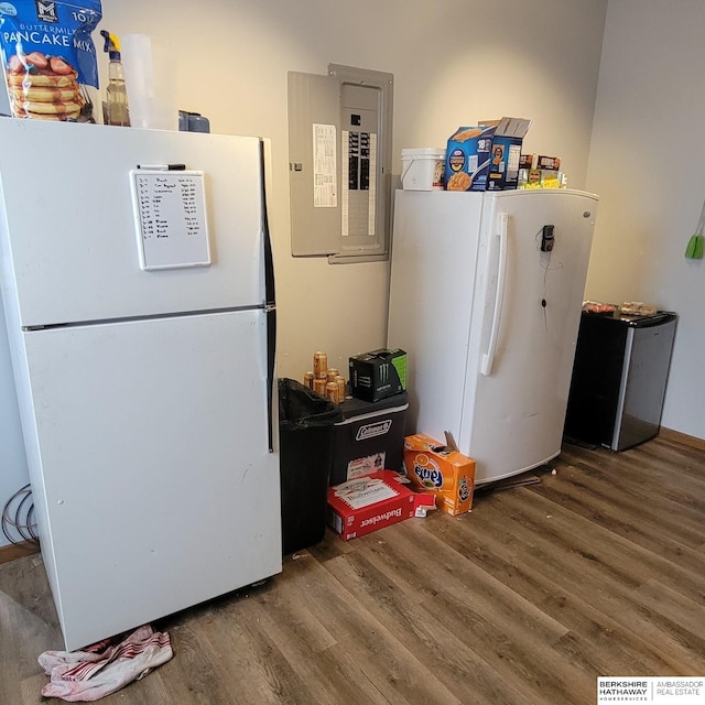 kitchen with freestanding refrigerator, electric panel, fridge, and wood finished floors