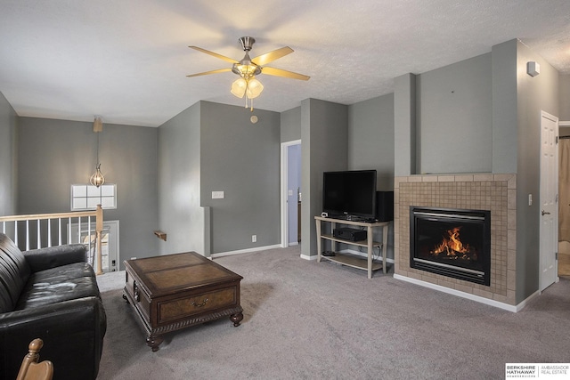 living area with a fireplace, visible vents, a ceiling fan, carpet flooring, and baseboards