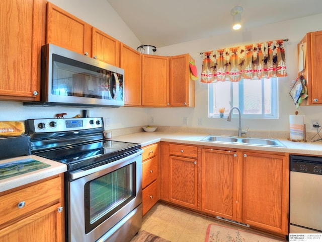 kitchen with appliances with stainless steel finishes, light countertops, and a sink