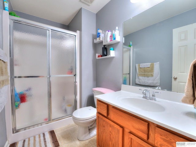 bathroom with toilet, visible vents, vanity, tile patterned floors, and a stall shower