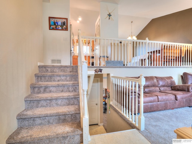 stairway with carpet floors, visible vents, vaulted ceiling, and a notable chandelier