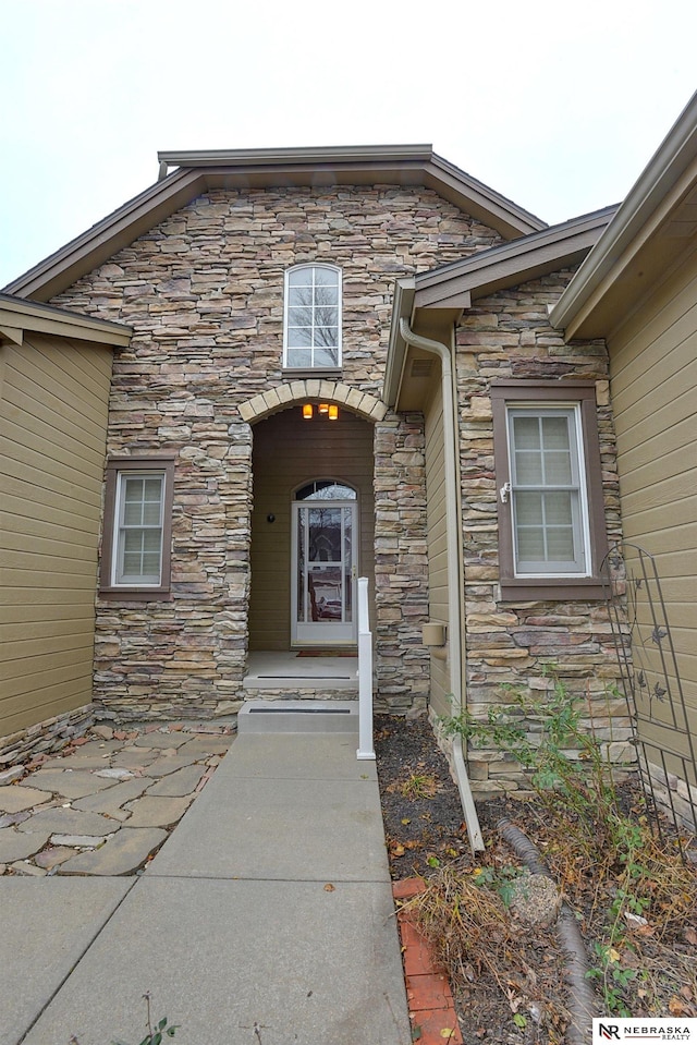 doorway to property featuring stone siding