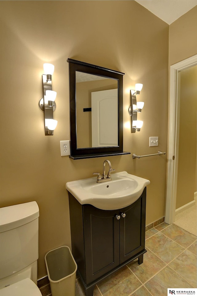 bathroom with vanity, toilet, and baseboards