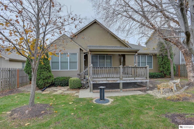 view of front of property featuring fence, a front lawn, and a wooden deck