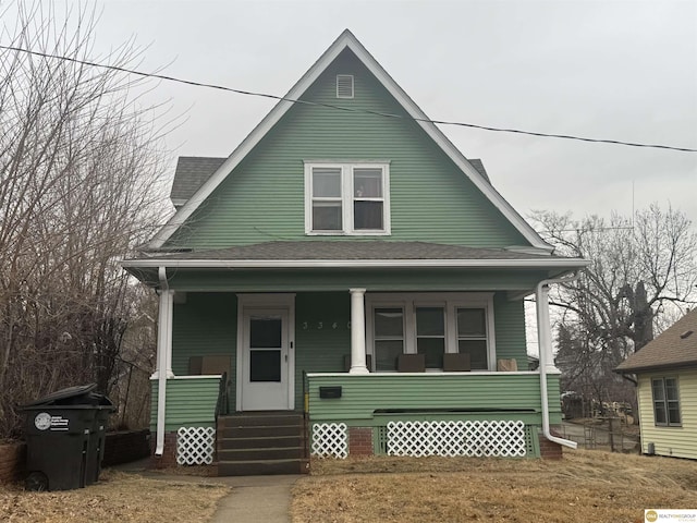 bungalow-style home with covered porch and roof with shingles