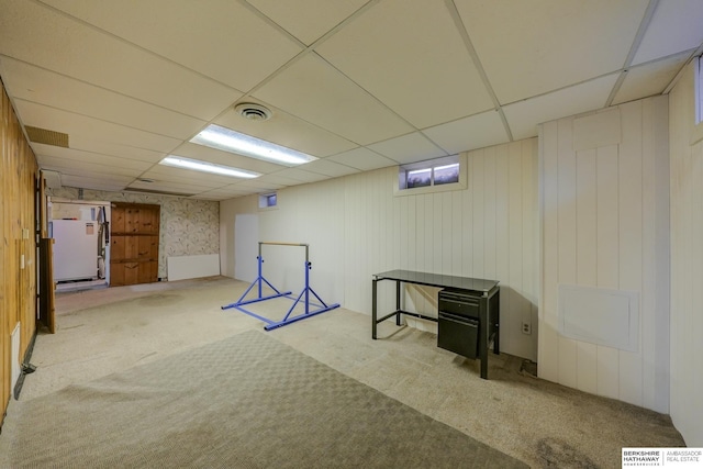 finished basement featuring a paneled ceiling, carpet, and visible vents