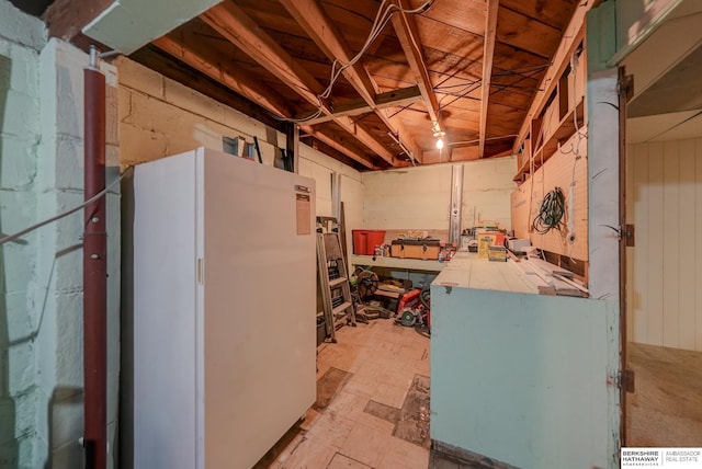 basement featuring freestanding refrigerator