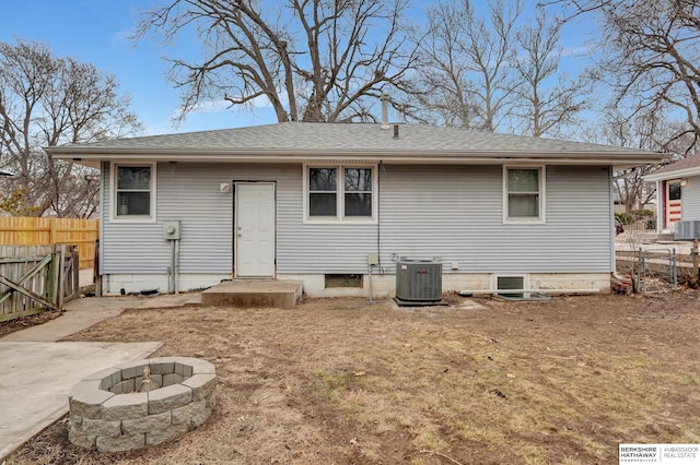 back of house featuring a shingled roof, central AC, fence, and a fire pit