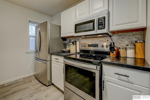 kitchen with dark countertops, visible vents, appliances with stainless steel finishes, and tasteful backsplash