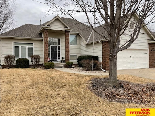 view of front of house with concrete driveway, brick siding, roof with shingles, and a front lawn